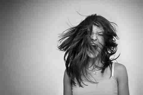 An angry teenage girl screaming in a black and white photo. Get disruptive mood dysregulation disorder treatment.