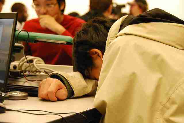 Autism and Pathological Demand Avoidance, Sleep Deprivation in Teens, Boy wearing a white hoodie sits in class with his head on the desk.