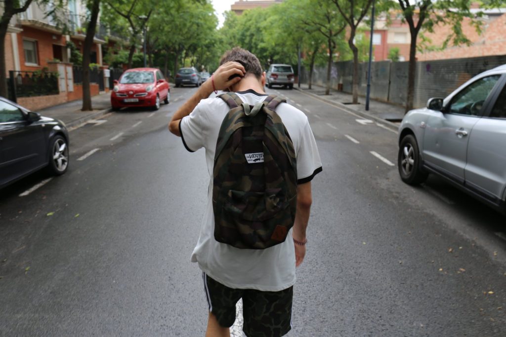 Addressing School Refusal - Teen wearing a backpack roams the streets, instead of attending school.