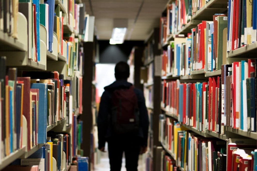 Student standing in a library. Wilderness therapy for personalized learning, supporting students with learning disabilities.